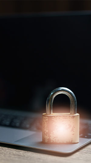 A pad lock resting on a laptop.