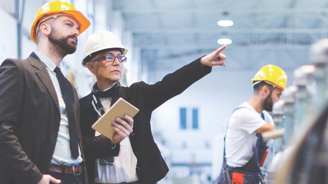 A man and a woman discussing some portion of a construction project.