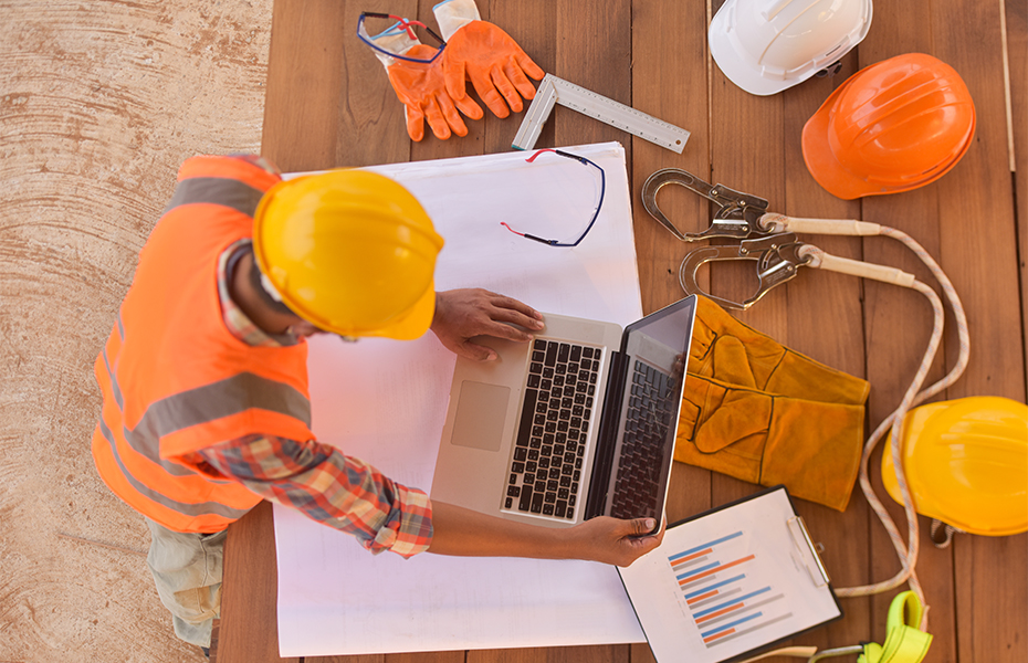 A construction worker working at a computer.