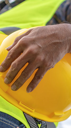 A hand holding a construction helmet.