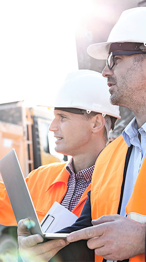 Two construction workers inspecting a build site.