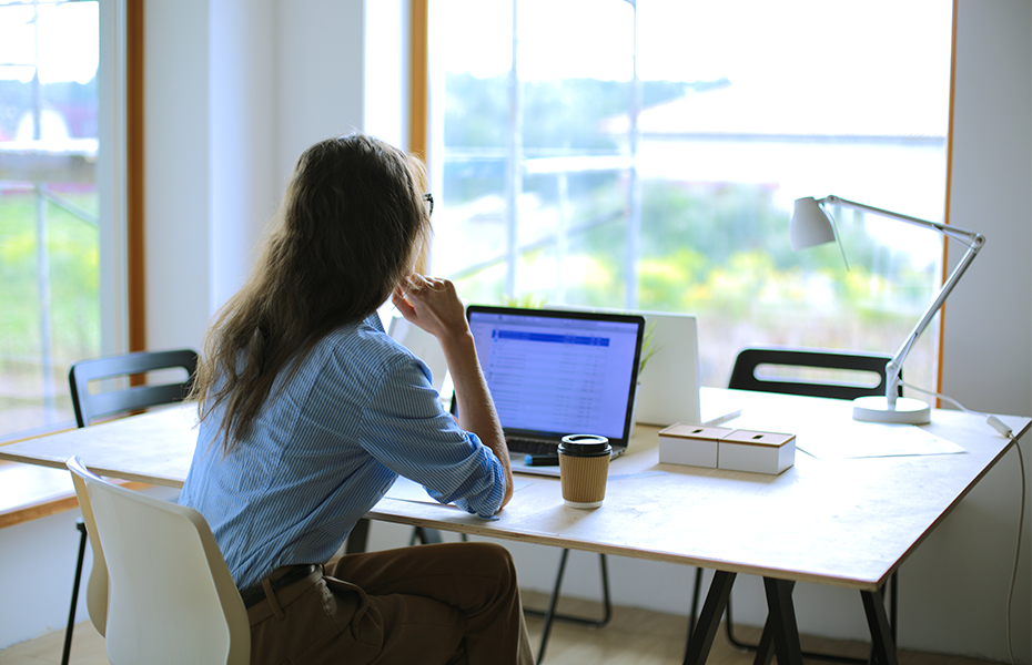 Business woman sitting at a desk looking at laptop