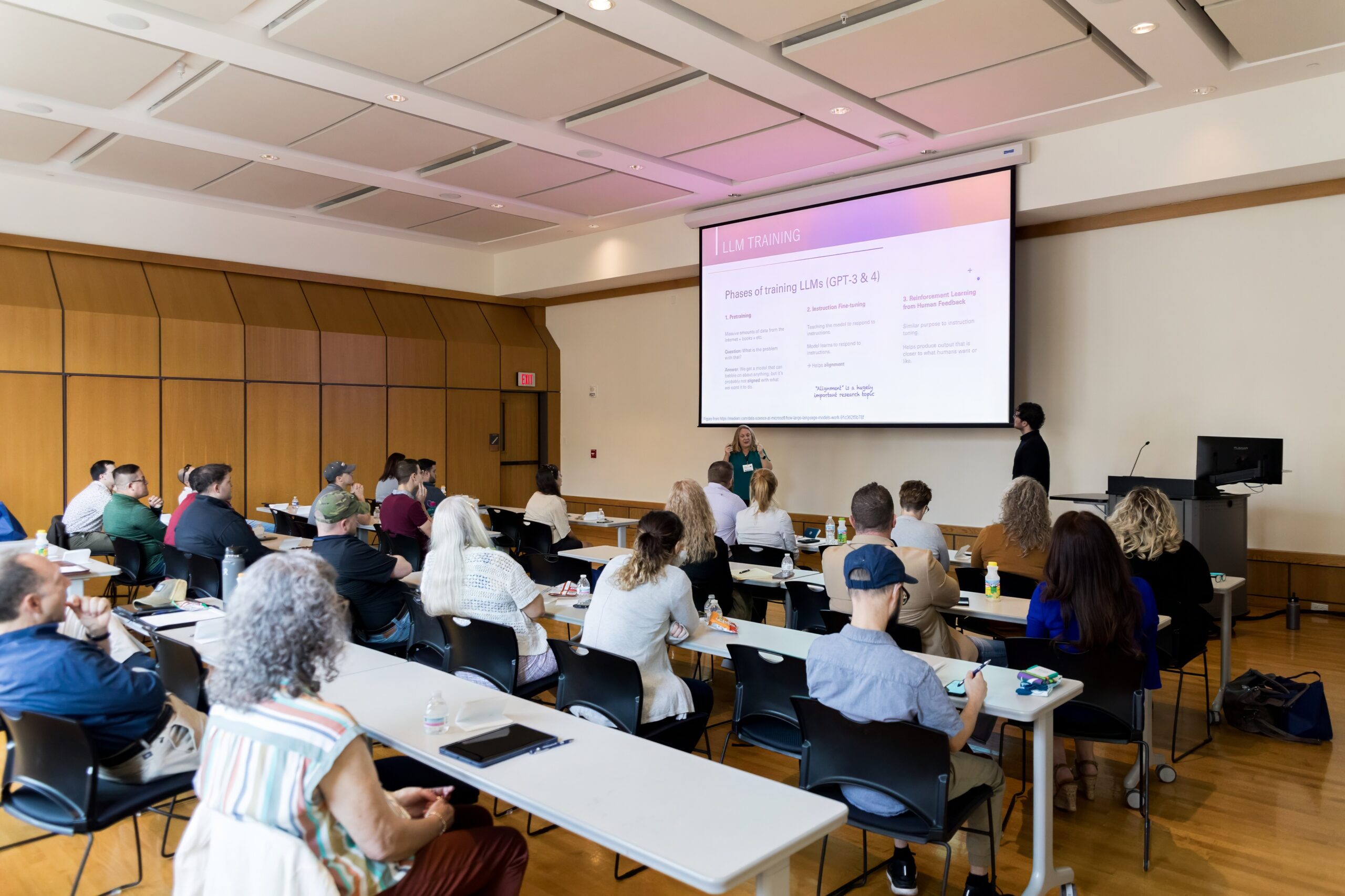 BIG U presenters Stephanie Schwartz and Jacob Smith presenting on AI in a room full of attendees.