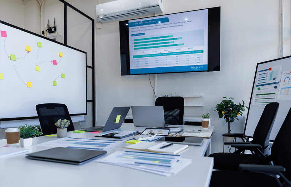Modern office workspace with a large monitor displaying a turquoise 