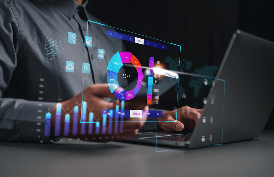 Person working at a laptop with holographic 3D data visualizations displayed above the screen, featuring a vibrant donut chart, colorful bar graphs in magenta, cyan, and orange, and interactive dashboard elements.