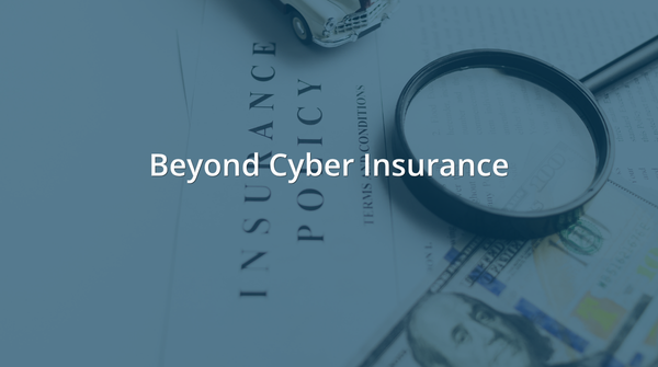 Insurance policy document with a magnifying glass resting on top, alongside a small toy car and U.S. currency, all under a blue-gray overlay. White text reads: Beyond Cyber Insurance.